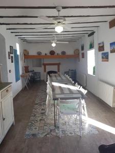 uma sala de jantar com uma mesa e uma ventoinha de tecto em Alojamiento Rural Las Viñas em Torredonjimeno