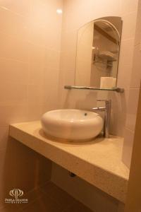 a bathroom with a white sink and a mirror at PHELA GRANDE HOTEL in General Santos