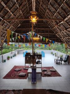 a large room with a table and a ceiling with flags at WoodPacker Hostel Auroville Pondicherry in Auroville