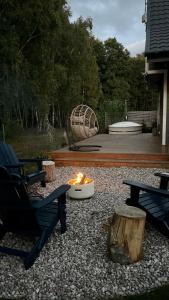 a fire pit in a yard with benches and a playground at Morski Klimat Sasino in Sasino
