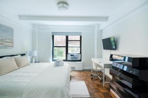 a white bedroom with a bed and a desk at Beautiful 1 Bedroom Apartment in New York