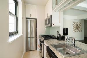 a kitchen with a sink and a stainless steel refrigerator at Beautiful 1 Bedroom Apartment in New York