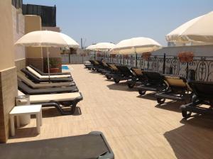 une rangée de chaises longues et de parasols sur le toit dans l'établissement Windsor Hotel, à Sliema