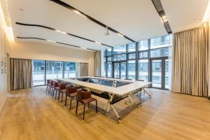 a pool table in a room with chairs and windows at Kew Green Hotel Mianshuicheng Haikou in Haikou