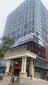 a large tall building with people standing in front of it at Vienna International Hotel - Changsha Yuelu Lugu Hi-Tech Zone in Changsha