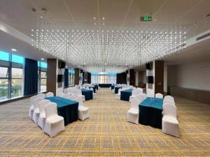 un salón de banquetes con mesas azules y sillas blancas en Vienna International Hotel - Changsha Yuelu Lugu Hi-Tech Zone en Changsha