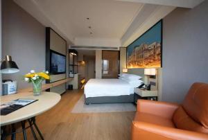 Habitación de hotel con cama, mesa y sofá en Vienna International Hotel - Changsha Yuelu Lugu Hi-Tech Zone en Changsha