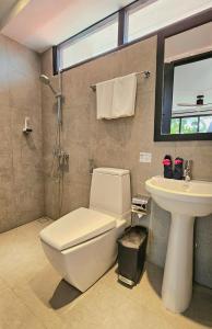 een badkamer met een wit toilet en een wastafel bij Dhigurah Cottage in Dhigurah