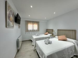 Cette chambre comprend 2 lits et une télévision à écran plat. dans l'établissement La Villa de Alba - Casa Rural en Montefrío, à Montefrío