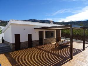 une maison avec une terrasse en bois et une table dans l'établissement La Villa de Alba - Casa Rural en Montefrío, à Montefrío