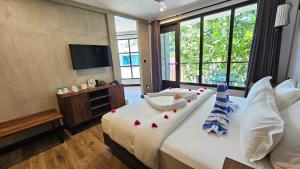 a bedroom with a large bed with pillows and a television at Dhigurah Cottage in Dhigurah