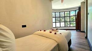 a bedroom with a bed with red flowers on it at Dhigurah Cottage in Dhigurah