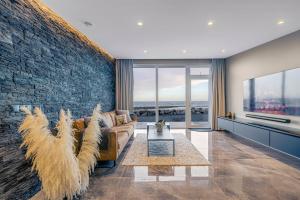 a living room with a couch and a stone wall at Bay View Apartments in Gardur