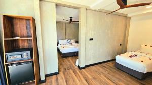 um quarto com duas camas e uma televisão em Dhigurah Cottage em Dhigurah