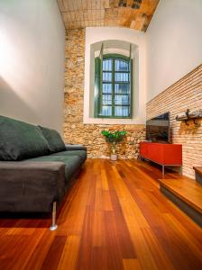 - un salon avec un canapé et un mur en briques dans l'établissement dúplex st. pere, à Gérone