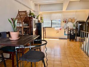 cocina con mesa y sillas en una habitación en Baan KhaoSoi - Private room in a rooftop hostel 2nd floor, en Khlong San