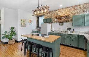 a kitchen with green cabinets and a island with bar stools at Cozy Home near Downtown - Close to Nulu - Sleeps 6 in Louisville