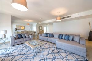 a living room with two couches and a table at Stunning Marina & Sea View 4 Bedroom Apartment, Murjan 6 Jumeriah Beach in Dubai