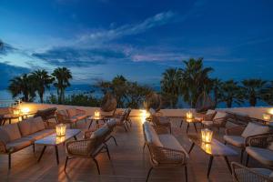 a patio with chairs and tables and lights at night at HOTEL SISSY in Kamena Vourla