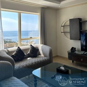 a living room with a couch and a glass table at Seafront Luxury Suites Jeddah Corniche in Jeddah