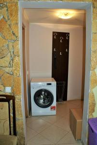 een wasmachine en droger in een kamer met een deur bij Aurora in Sutomore