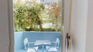 uma mesa e cadeiras numa varanda com uma janela em Unique Serviced Living @ St. Johann (Davidsboden) em Basileia