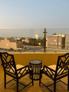 two chairs and a table on a balcony with a view at مسكن نون للشقق المخدومة in Jeddah
