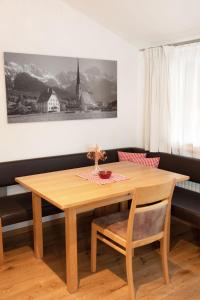 een eettafel met een houten tafel en stoelen bij Erlenhof in Maria Alm am Steinernen Meer