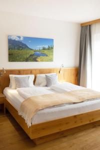 una camera con un grande letto con struttura in legno di Erlenhof a Maria Alm am Steinernen Meer