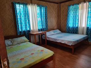 a small bedroom with two beds and a table at ITAYTAY INN in San Vicente