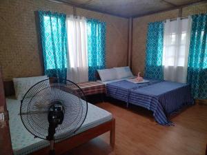 a room with a bed and a fan in a room at ITAYTAY INN in San Vicente +34 photos