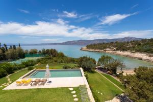 an overhead view of a pool with chairs and a body of water at Villa Aria - Luxury Beachfront Villa with Pool and Tennis Court in Koilás