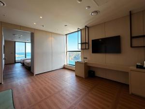 a large living room with a bed and a television at Ulsan Tanibay Hotel & Wedding in Ulsan