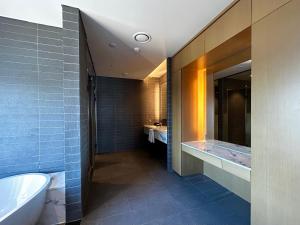 a bathroom with a tub and a toilet and a sink at Ulsan Tanibay Hotel & Wedding in Ulsan