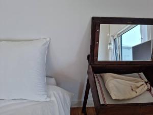 espejo junto a una cama con almohada blanca en B&G House, en Gyeongju