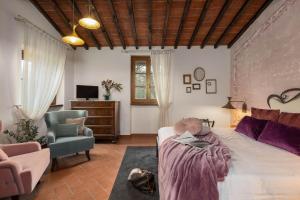 a bedroom with a bed and a couch and a chair at DormiVeglia B&B in Monte San Savino