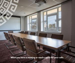 uma sala de conferências com uma grande mesa de madeira e cadeiras em Hotel Galatea em Mladá Boleslav