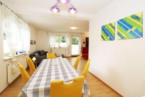 特拉森海德Ferienhaushälfte Hubertus的一间带桌子和黄色椅子的用餐室