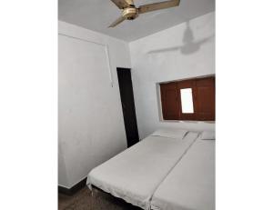 um pequeno quarto com uma cama e uma janela em Vineet Hotel,Prayagraj em Prayagraj