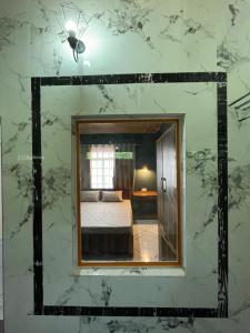 Rilassare stays cottage في Pedong: مرآة في غرفة مع سرير