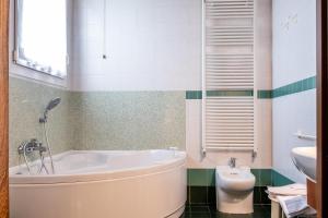 a bathroom with a tub and a toilet at B&B Hotel Roy in Silea