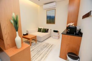 Suffah Chalet في نزوى‎: غرفة معيشة مع أريكة بيضاء وتلفزيون