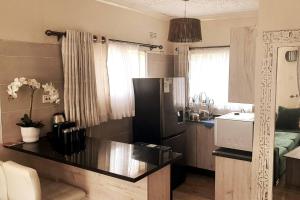 a kitchen with a black refrigerator and a sink at Gorgeous 1-Bed apartment in Harare in Harare