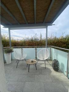 - une terrasse avec 2 chaises et une table dans l'établissement Wohnung im Grünen am Stadtrand, 50 m2, eigener Garten mit Terrasse, eigener Eingang, kostenloses Parken, à Salzbourg