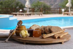 a tray of bread and corn on a table near a pool at Amorgion Village in Katapola