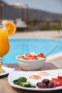 a bowl of fruit on a table with a drink at Amorgion Village in Katapola