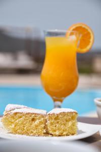 a piece of cake and a glass of orange juice at Amorgion Village in Katapola