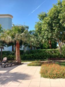 park z ławką, palmami i wieżą wodną w obiekcie Brand New Cozy Studio Apatrtment w Dubaju