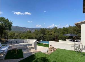 a view of a backyard with a pool and grass at La tanière studio in Les Brugassières