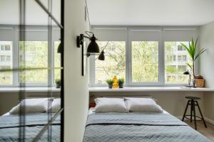 a bedroom with two beds and two windows at Cozy apartment in Zverynas in Vilnius
